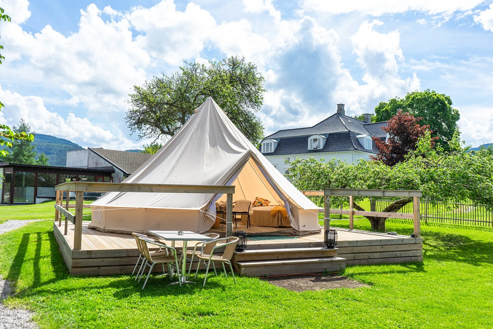 Möblerat glampingtält i grön sommarmiljö