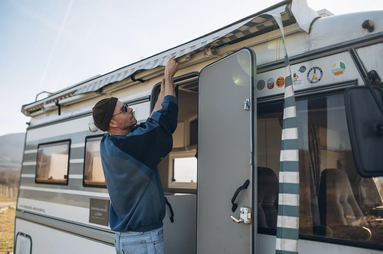 Person som ställer i ordning en campervan nära berg